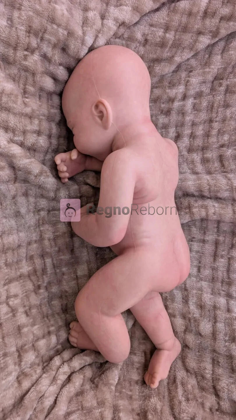 Neonata reborn che sembra vera in una naturale posizione da appena nata