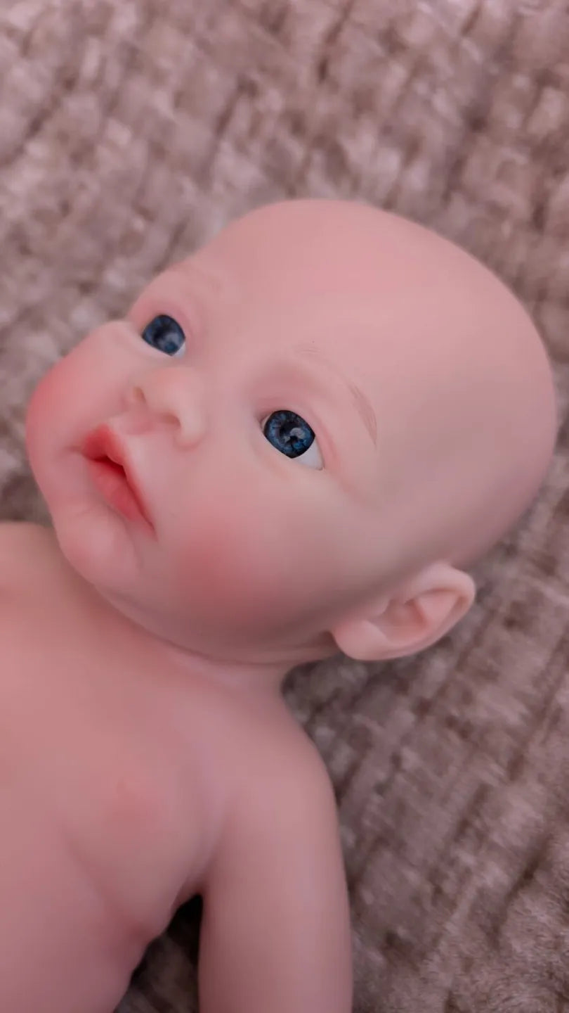 bambola reborn con il viso realistico e che sembra vera con gli occhi aperti