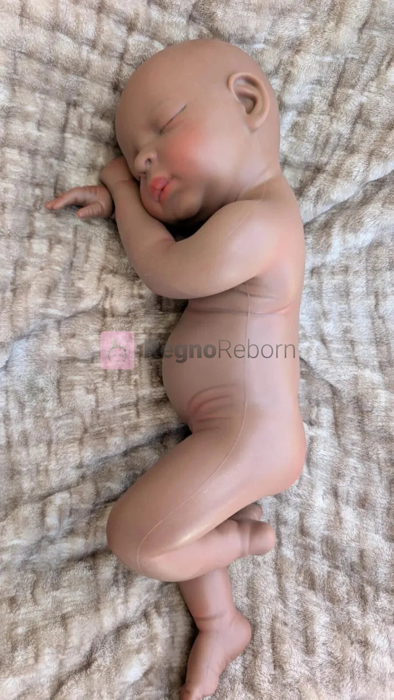 Bambola reborn africana 45 cm in posizione naturale da neonato con una gamba piegata