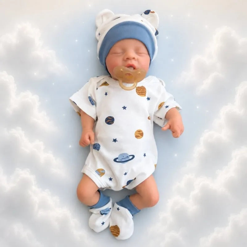 bambola reborn maschio con gli occhi chiusi e con vestiti da neonato bianco e blu