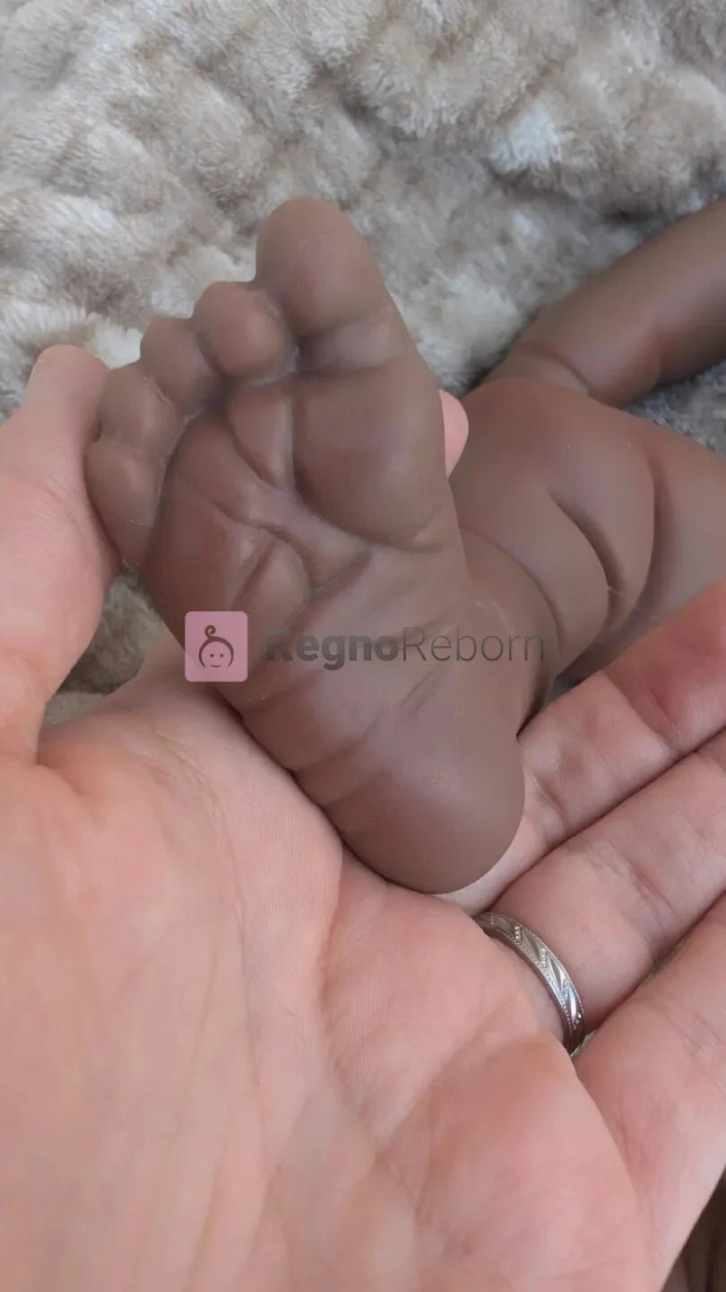 Bambola reborn nera realistica con dettaglio del piede