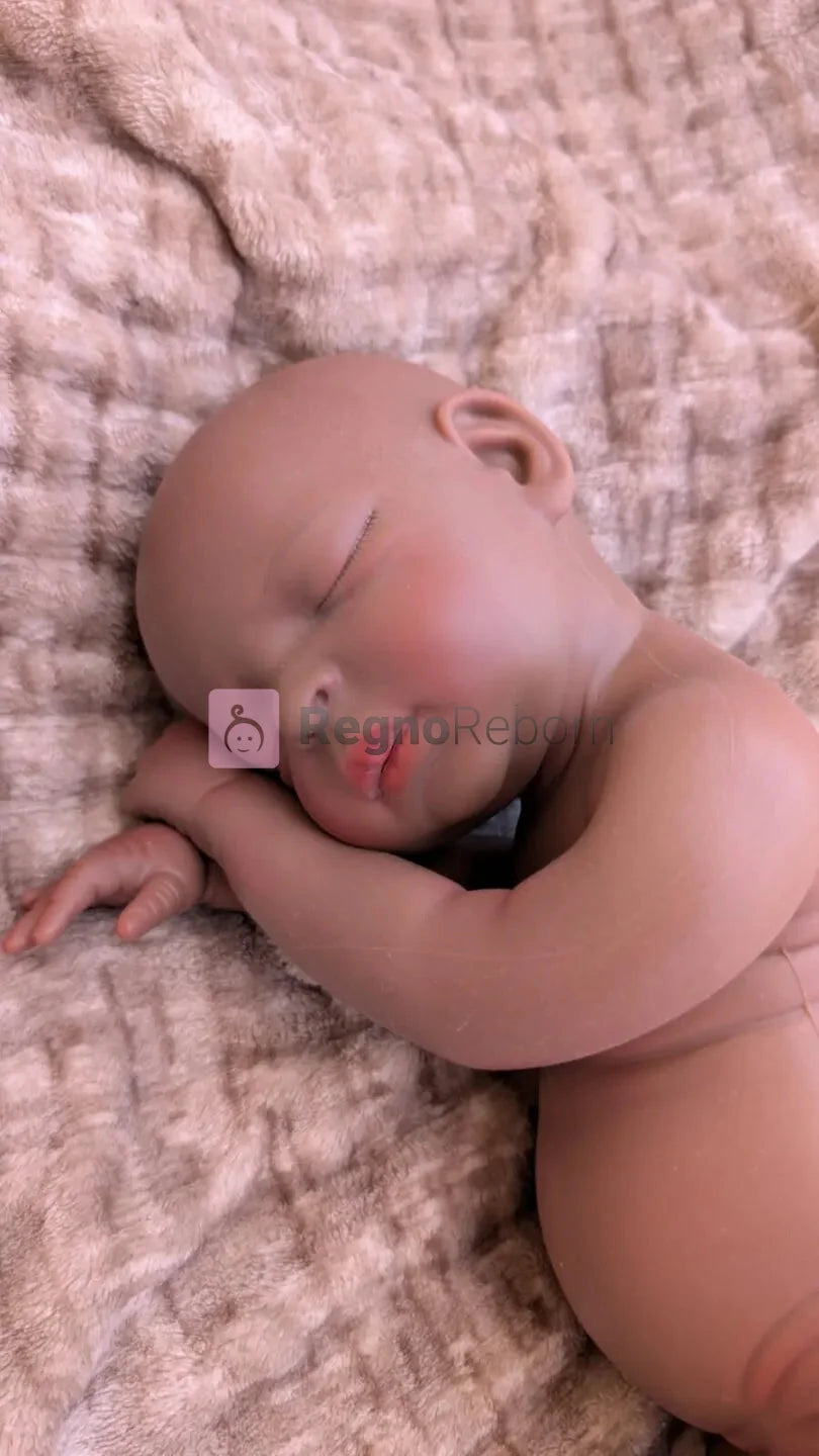 Neonata reborn africana in una naturale posizione da bambina appena nata