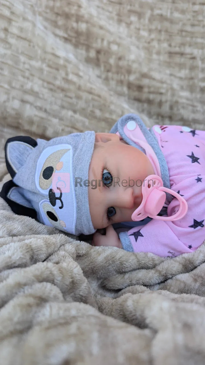 Bambola-reborn-sdraiata-pancia-in-giu-in-posizione-neonato con ciuccio nella bocca