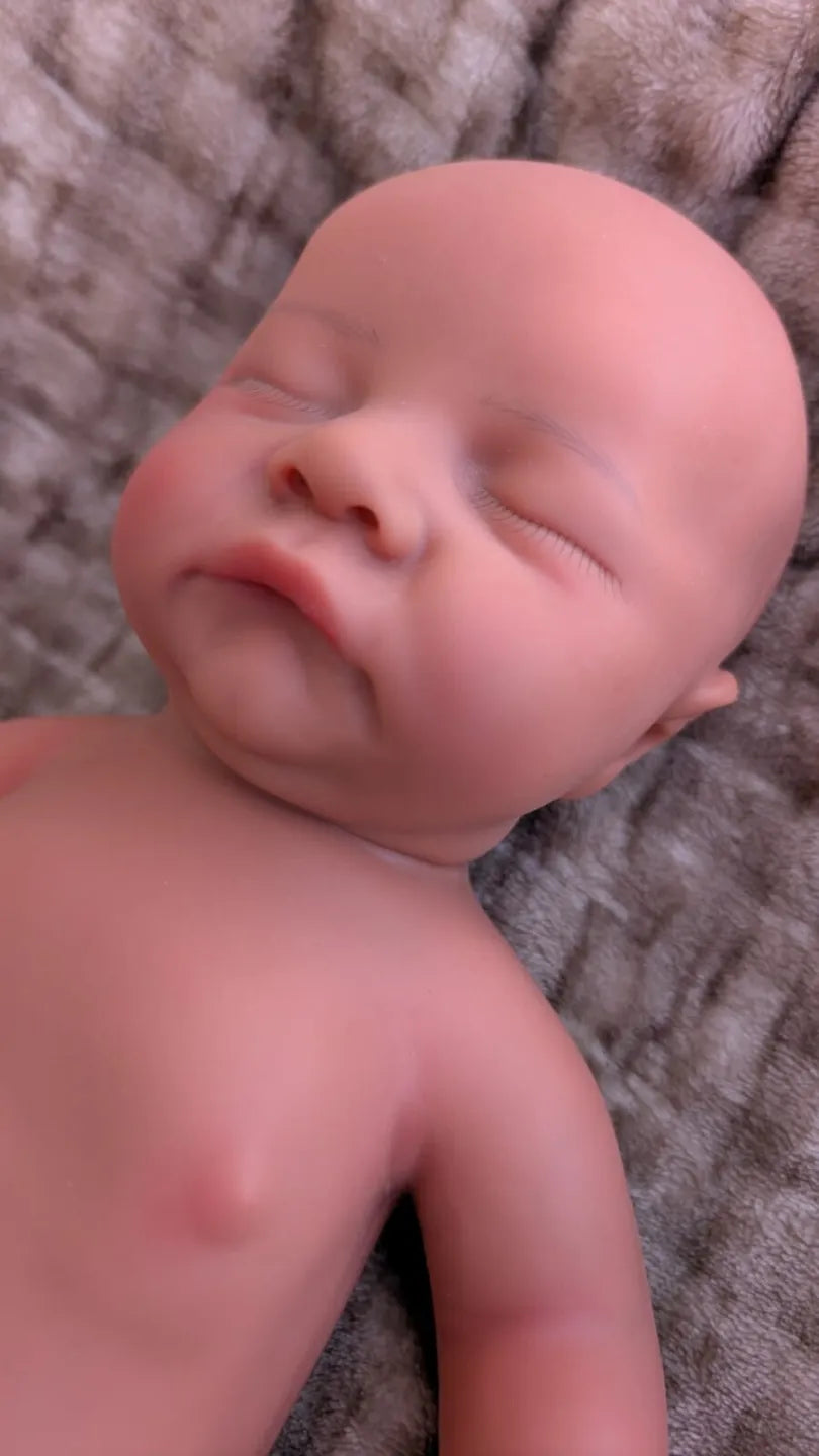 bambola che si morde le labbra e che sembra un vero neonato addormentato di 45cm