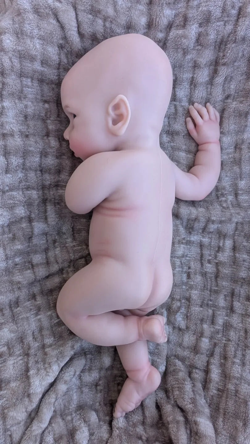 Bambola che sembra vera di 40 cm in una naturale posizione da neonato