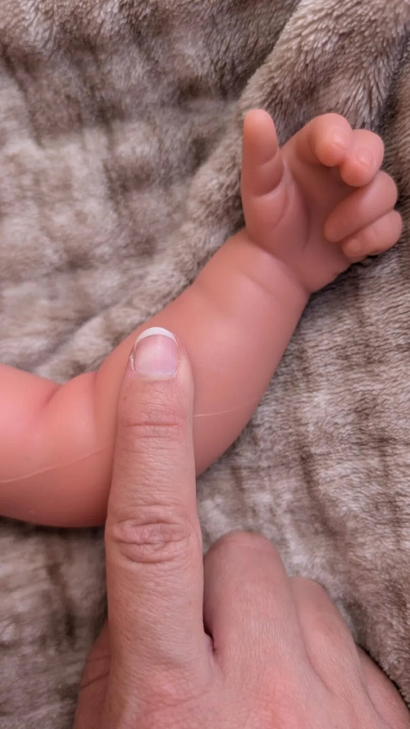 Mano della bambola reborn con dita e pieghe della pelle realistiche