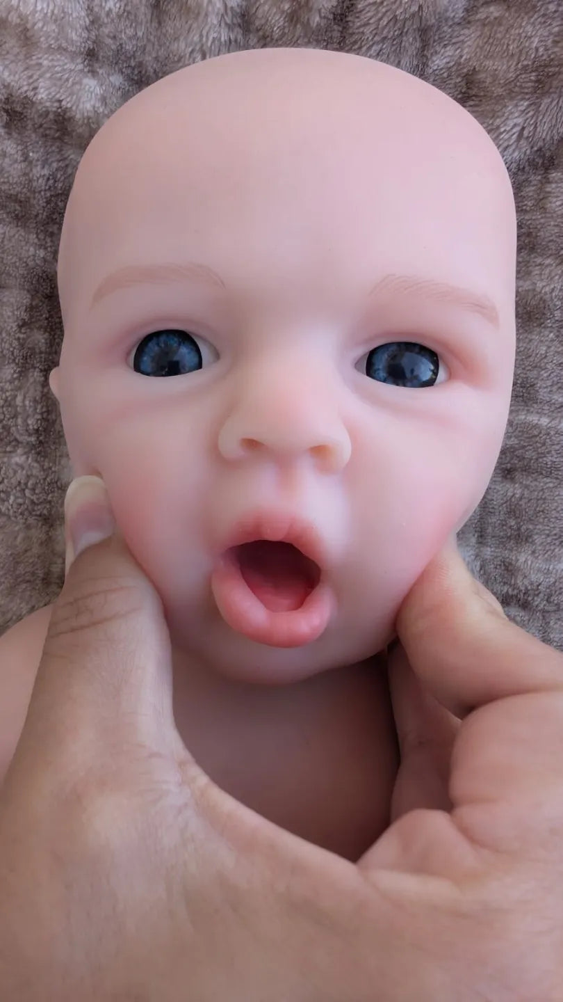 Bocca del neonato reborn che si apre premendo delicatamente sulle guance