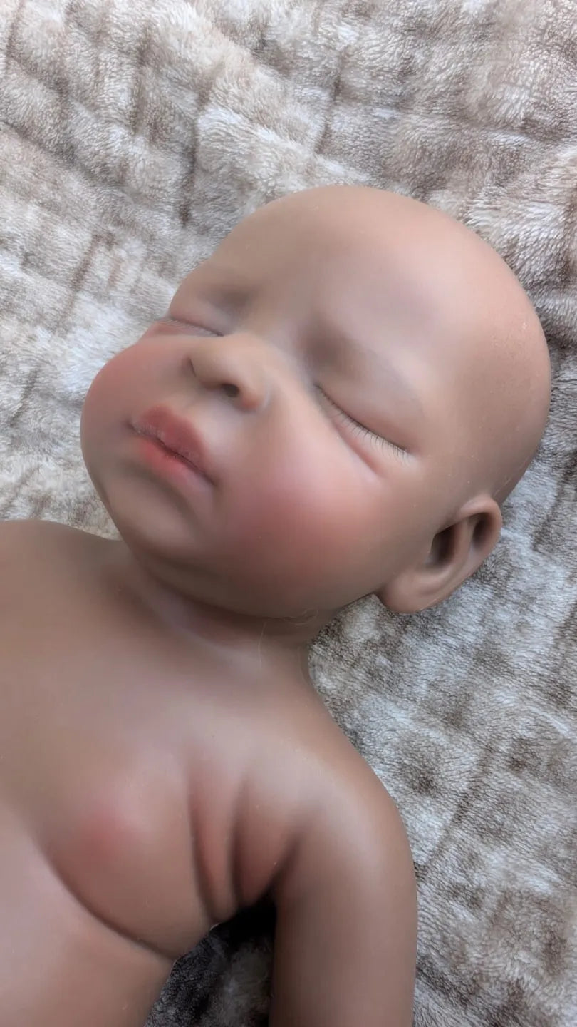 Primo piano del viso realistico addormentato della bambola reborn nera 45 cm