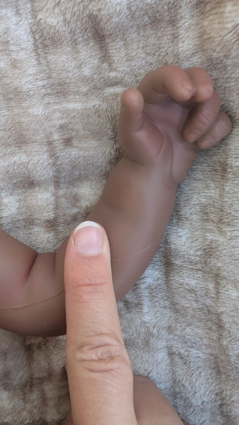 Bambola reborn nera in silicone flessibile con mano e pieghe della pelle realistiche