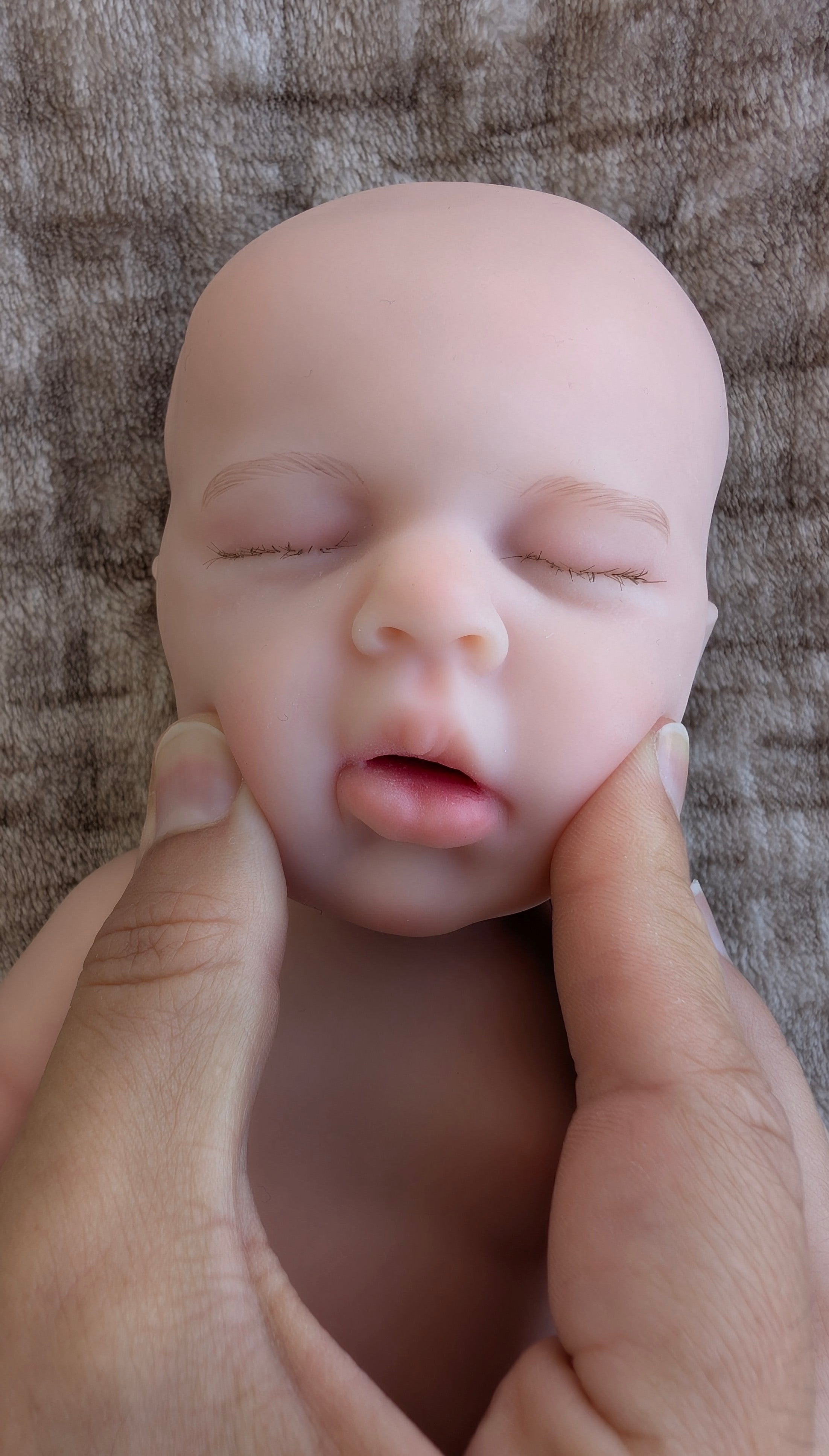 piccola bambola reborn in silicone con la bocca che puo aprirsi premendo le guance per inserire un ciuccio da neonato