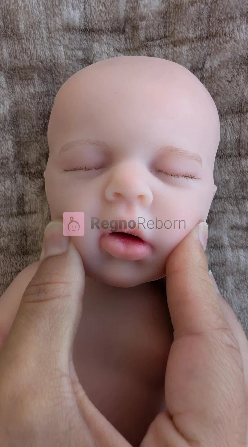 piccola bambola reborn in silicone con la bocca che puo aprirsi premendo le guance per inserire un ciuccio da neonato