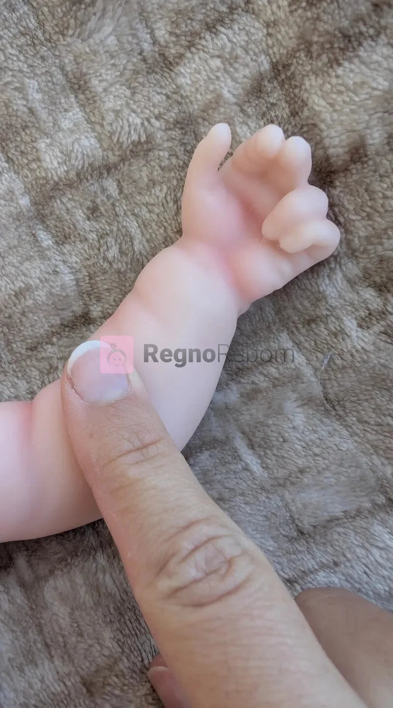 Mano e pieghe del polso di un bambolotto reborn prematuro in silicone