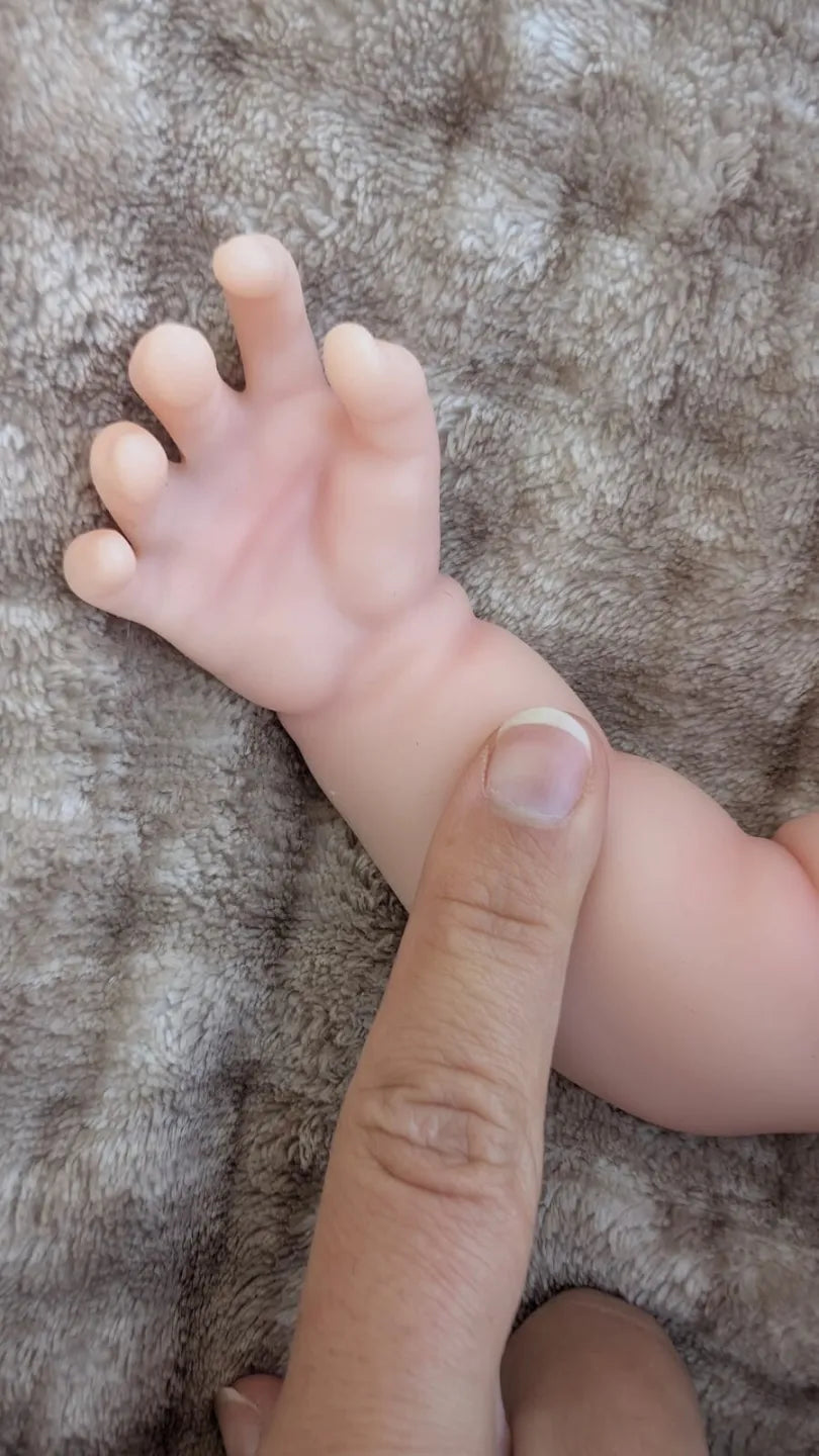 Braccio e mano della bambola reborn che mostra gli dettagli realistici del silicone morbido