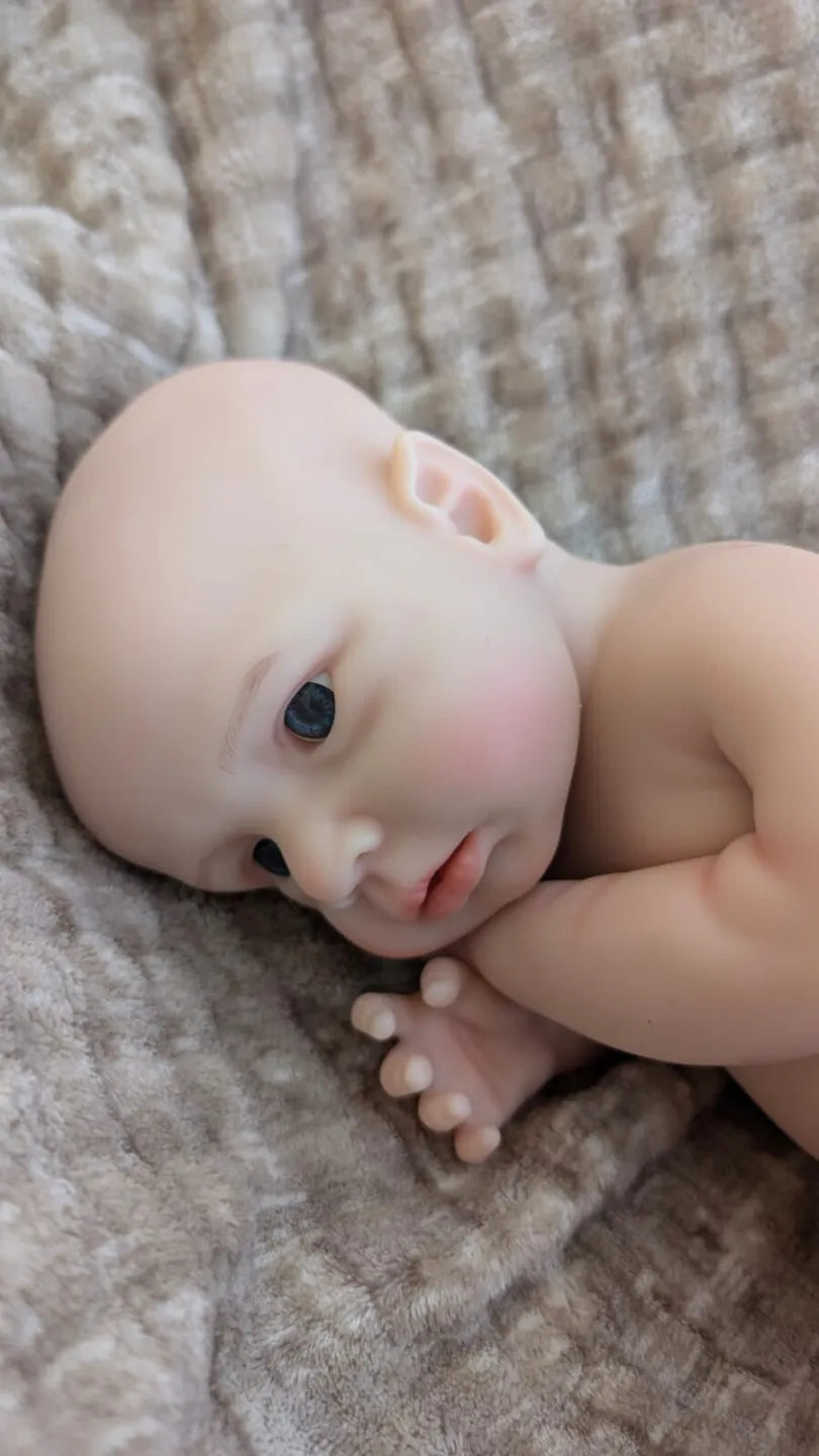 neonato reborn maschile di 40 cm in una tenera posizione da neonato