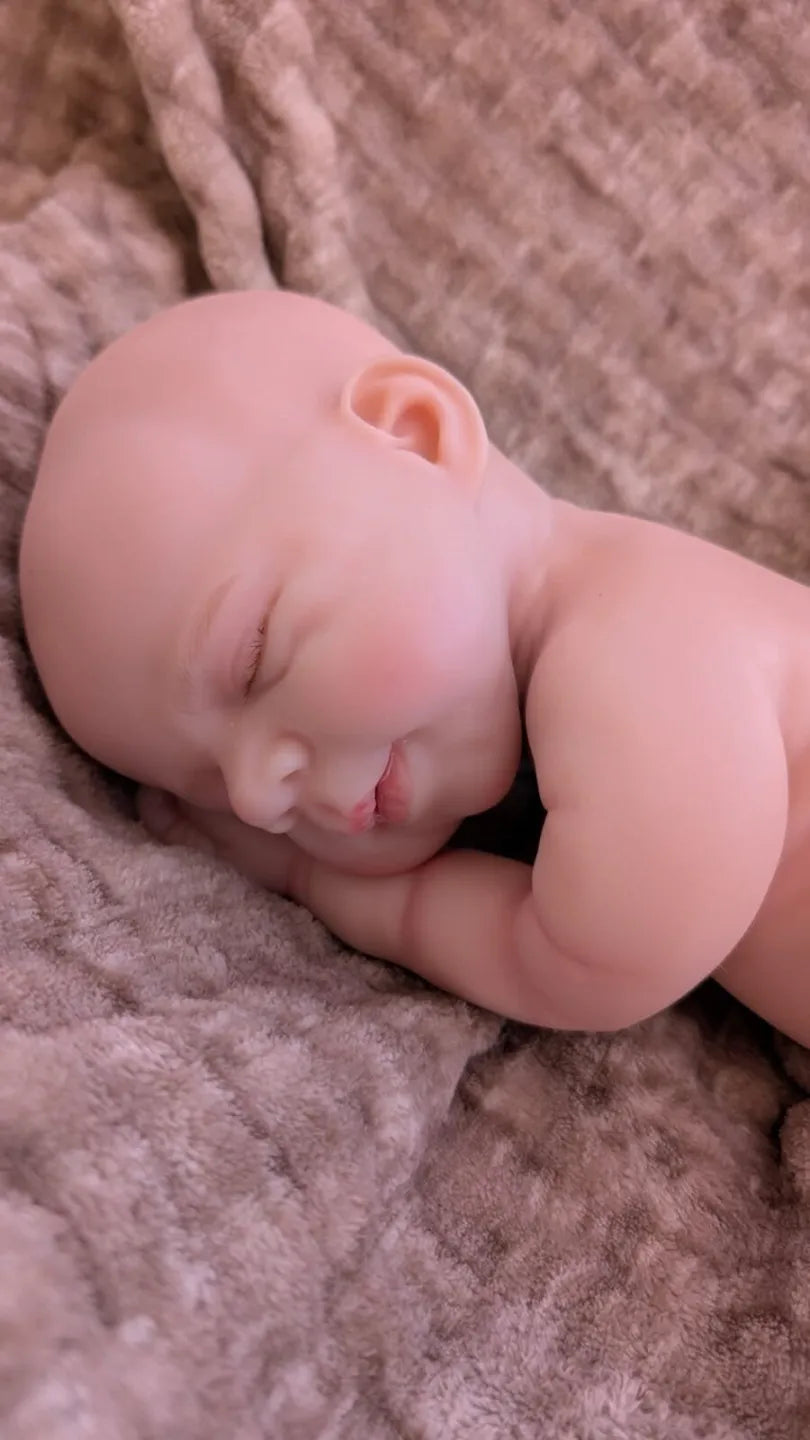 Bambola che sembra vera di 40 cm in una naturale posizione da neonato