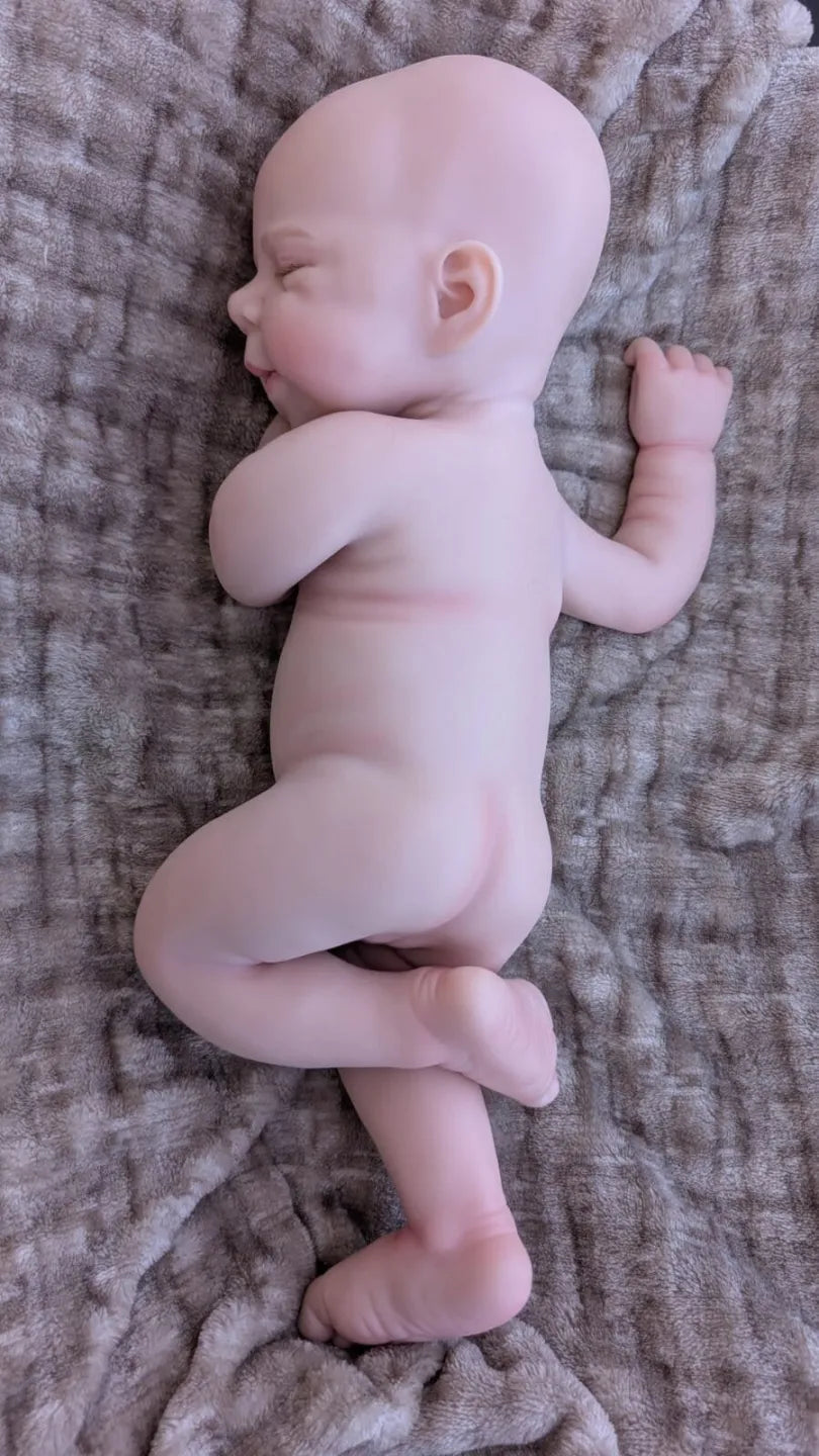 Bebè reborn di 40 cm in una tenera posizione da neonato