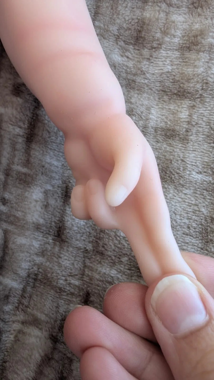 mano elastico del neonato reborn che mostra la flessibilita del silicone