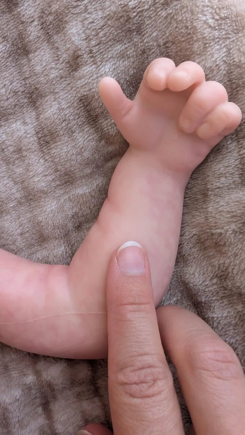 Dettaglio della mano e delle pieghe della pelle del neonato che sembra vero