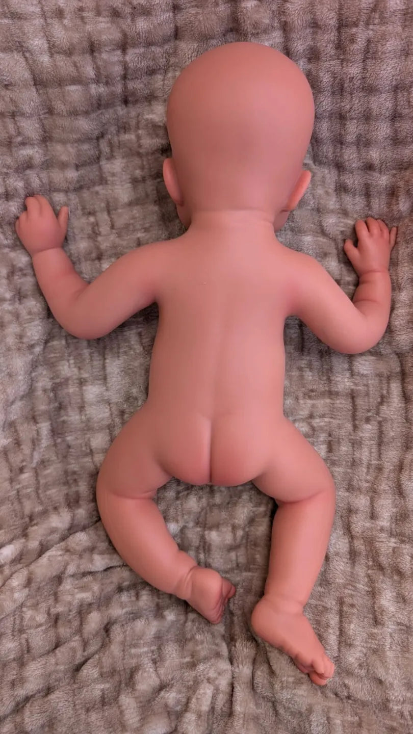 viste posteriore del neonato reborn di 50cm con le gambe e braccia divaricate per mostrare la flessibilità del silicone