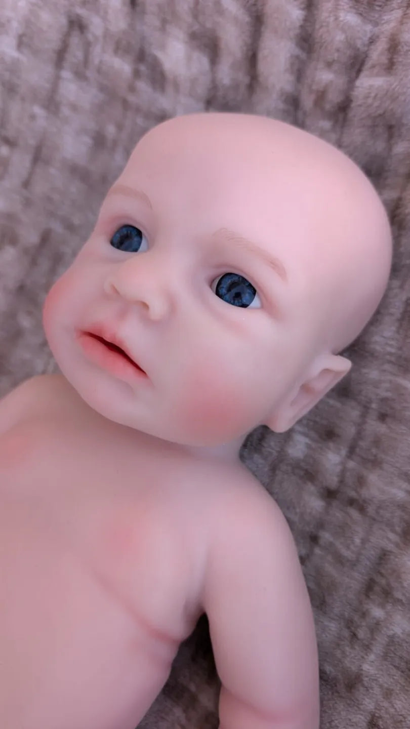 Primo piano del viso realistico del neonato reborn maschietto in silicone con gli occhi aperti